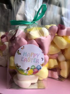 a bag filled with marshmallows sitting on top of a pink table next to other bags