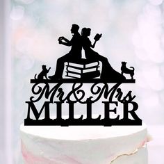 a wedding cake topper that says mr and mrs miller with cats sitting on it