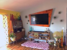 a living room filled with furniture and a flat screen tv mounted to the side of a wall