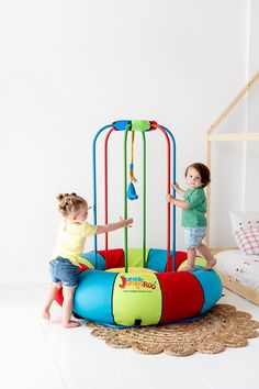 two young children playing in a play gym