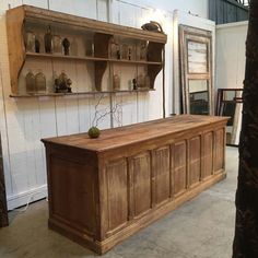 an old wooden cabinet with shelves and vases on the top shelf in a room