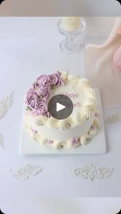 a cake with white frosting and pink flowers on it