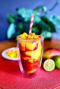 a glass filled with fruit sitting on top of a red place mat