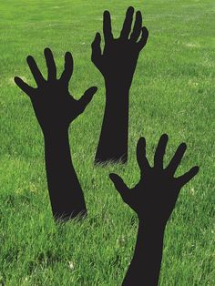 two silhouettes of hands reaching up in the grass