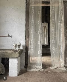 an open door leading to a bathroom with white curtains