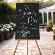 a black and white sign sitting on top of a wooden easel next to potted plants