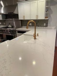 a kitchen with an island counter and stainless steel appliances in the back drop off area