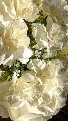 a bouquet of white flowers sitting on top of a table