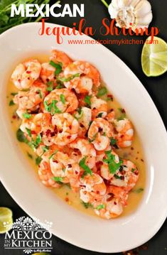 a white plate topped with cooked shrimp and garnished with cilantro sauce