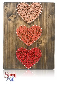 string art is displayed on a wooden board with three hearts in the shape of strings