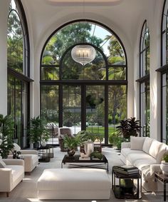 a living room filled with lots of furniture and large arched windows over the top of it