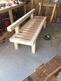 a bench made out of wood sitting in a garage next to other workbench