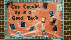 a bulletin board that has been decorated with halloween books and spider webs on it