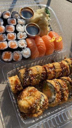 sushi and rolls in plastic containers on a table