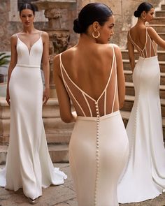 the back of a woman's wedding dress, with three other women standing around