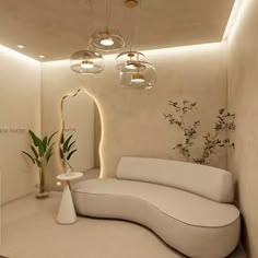 a white couch sitting next to a mirror in a room with lights on the ceiling