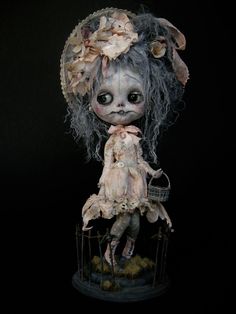 a creepy doll sitting in a cage with flowers on it's head and hair