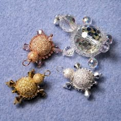 three pieces of jewelry sitting on top of a blue surface