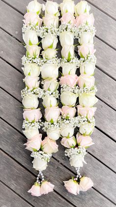 a bunch of white and pink roses arranged on a table with baby's breath