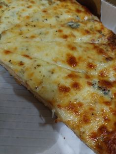 a slice of cheese pizza sitting on top of a white paper wrapper in a box