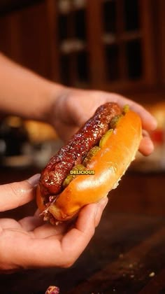 a person holding a hot dog in their hand