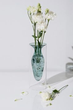 a glass vase with flowers in it sitting on a table