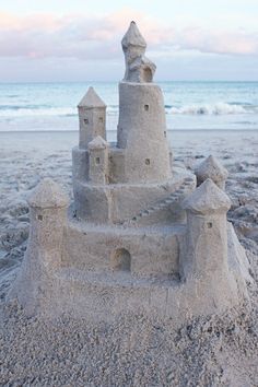 a sand castle sitting on top of a sandy beach