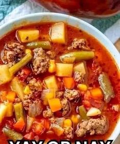 a white bowl filled with meat and vegetable soup