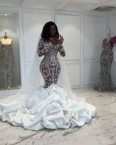 a woman in a wedding dress is taking a selfie with her cell phone while surrounded by mannequins