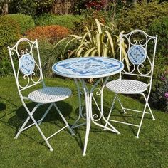 an outdoor table and chairs in the grass