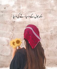 a woman holding a flower in front of her face with an arabic quote on it