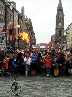 a woman on a unicycle in front of a crowd