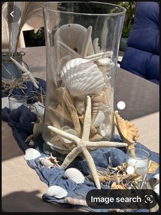 a glass vase filled with seashells and starfish