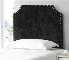 a black headboard with studded trim and white pillows