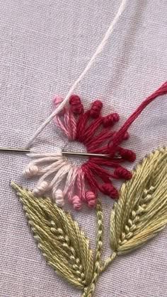 a close up of a piece of cloth with some flowers on it and thread in the middle