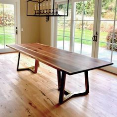 a large wooden table sitting in the middle of a room with french doors leading to an outside patio