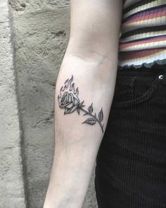 a woman's arm with a tattoo on it that has leaves growing out of it