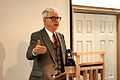 a man in a suit and tie giving a presentation