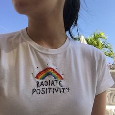 a woman wearing a t - shirt with the words radiate positivity on it