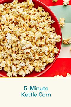 a red bowl filled with popcorn on top of a table