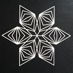 a white paper cut snowflake sitting on top of a table