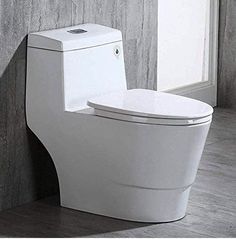 a white toilet sitting in a bathroom next to a wall with wood paneling on it