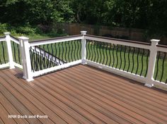 a wooden deck with white rails and railings