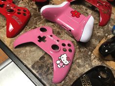 several different colored video game controllers on a counter