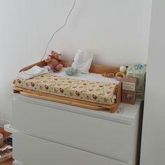 a baby's crib in the corner of a room with toys on it