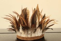 a brown and white hat with feathers on it