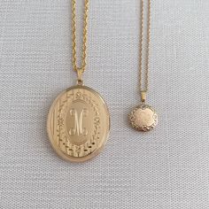 An adult-size 14K yellow gold-filled engraved floral signet oval locket on a rope chain necklace. The outer shell is solid gold pressure-bonded to an inner core of high-quality brass. Locket Dimensions: 30 mm W x 38 mm H Chain length: 22" Classic Gold Oval Locket Necklace, Classic Gold Locket Necklace With Oval Pendant, Yellow Gold Oval Pendant Locket Necklace, Gold Oval Heirloom Locket Necklace, Oval Etched Brass Jewelry, Heirloom Oval Etched Necklace, Oval Brass Necklace With Engraving, Engraved 14k Gold Oval Pendant Locket Necklace, Classic Brass Medallion Locket Necklace