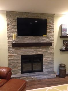 a large flat screen tv mounted on the wall above a fireplace