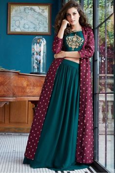 Feel an eccentric glow wearing this outstanding rama green designer lehenga choli set featuring a plain skirt complimented by same color choli enhanced with zardosi & zari worked butta at the centre of bodice looking tasteful in its charm! This lehenga choli set is accompanied with contrasting magenta long jacket done up in spread out zari & sequin motifs. Lehenga Choli Designs, Long Gown Dress