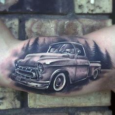 a man with a tattoo on his arm has an old truck in the woods